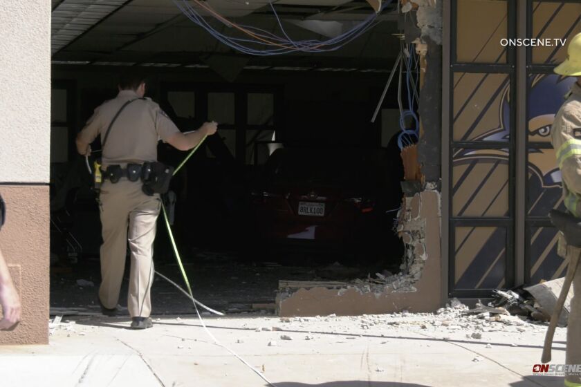 Authorities at the scene of a single-car crash into a building at Tomas Rivera Middle School on Wednesday that left eight adults injured. No students were hurt.