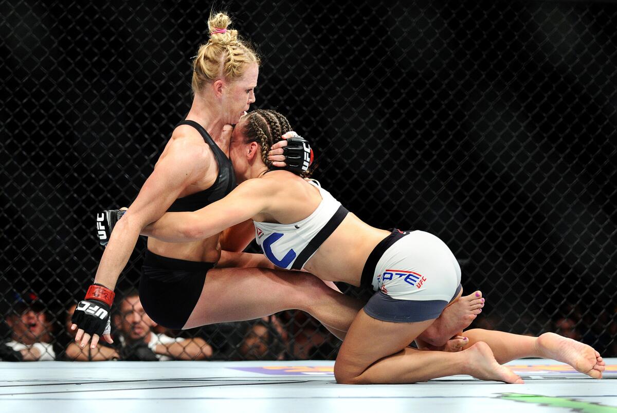 Miesha Tate takes down Holly Holm during their UFC 196 women's bantamweight title fight.