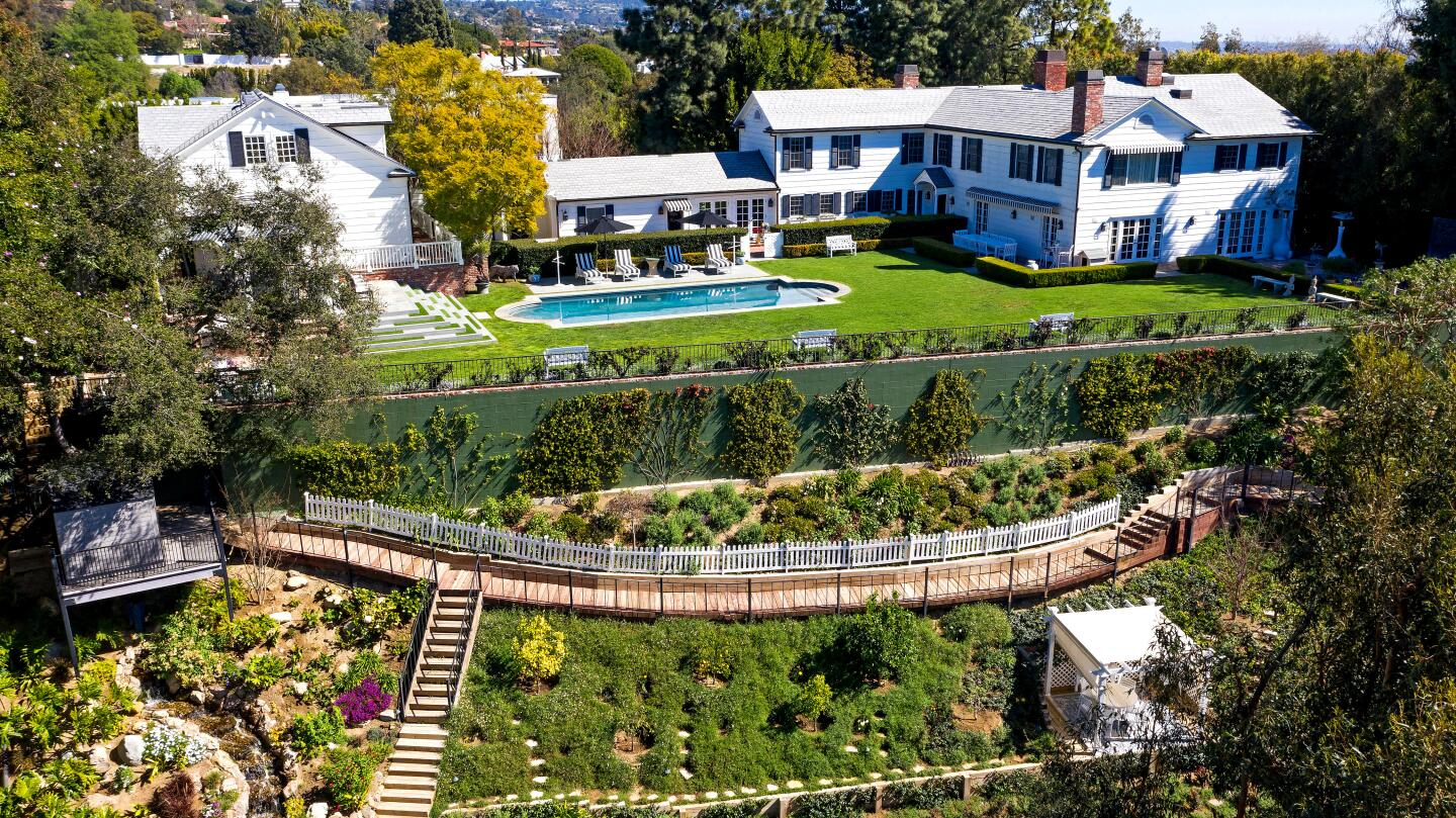 Nigel Lythgoe's property overlooks the Bel-Air Country Club golf course. It includes a 1930s residence and a two-story guesthouse. In between the two homes, a grassy backyard wraps around a swimming pool.