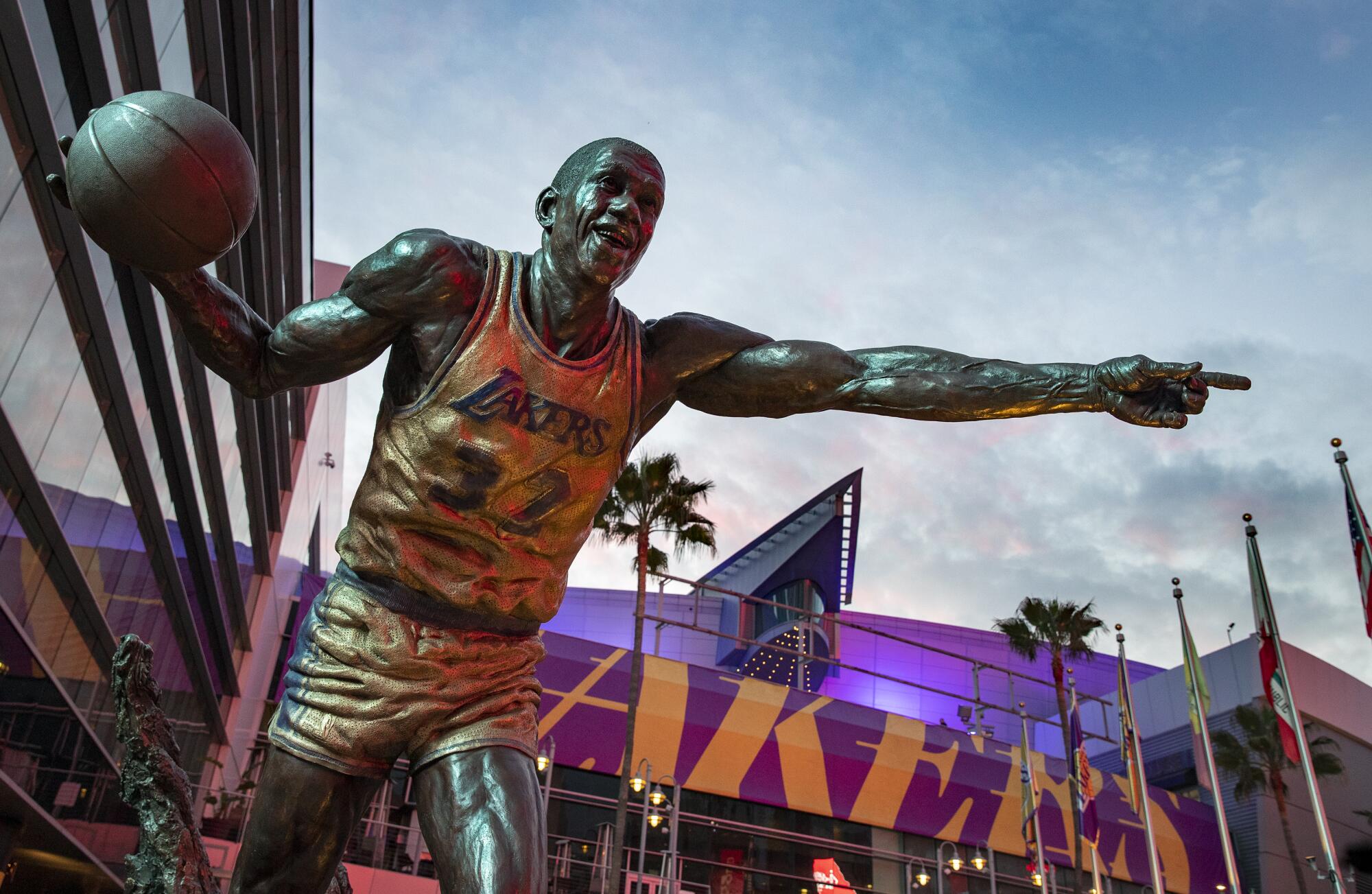 The statue of Magic Johnson towers above metal framing where a Staples Center sign once graced an entrance to the venue.