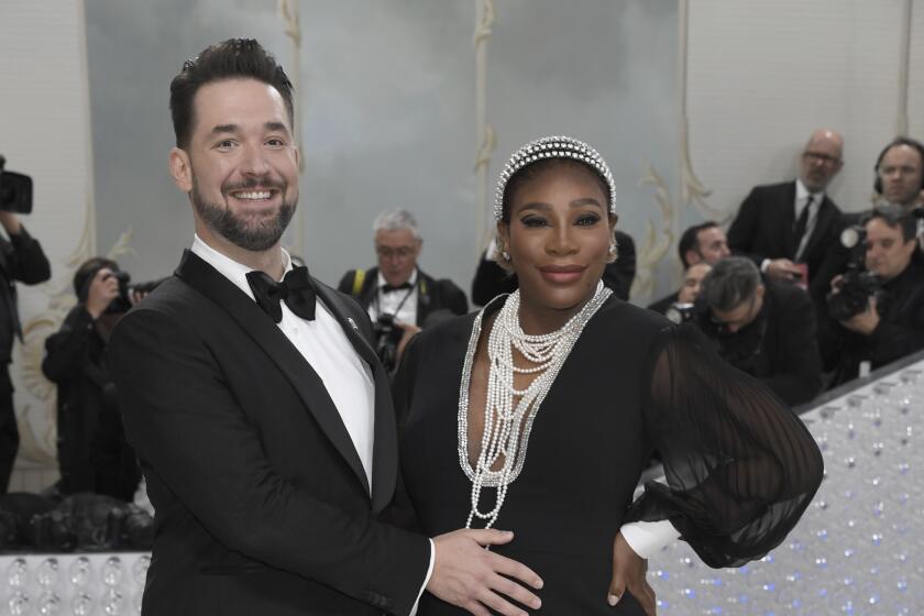 Alexis Ohanian, left, touches his wife Serena Williams' pregnant belly as they pose in formalwear