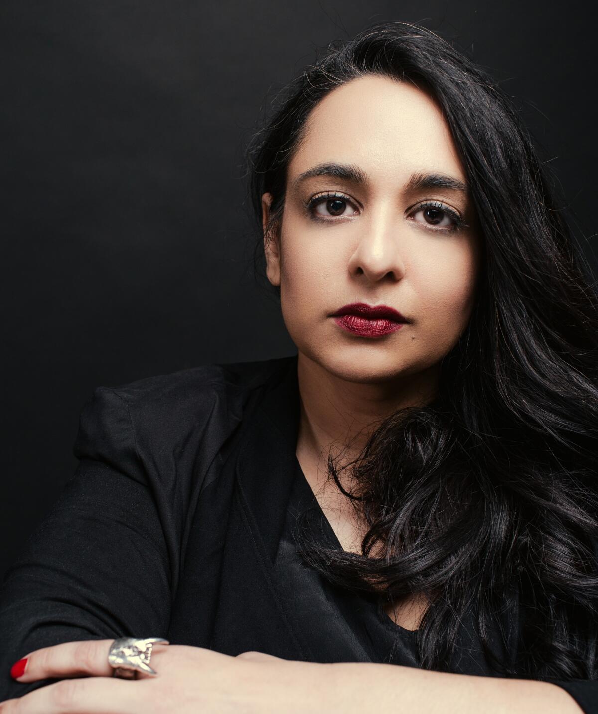 Author Amina Akhtar looks straight into the camera.