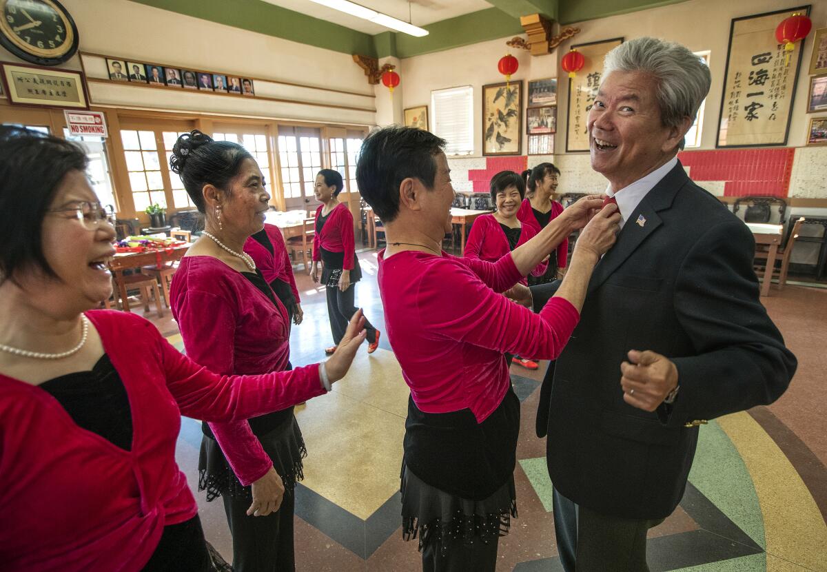 Hui-Hua Kwan adjusts the tie of Paxton Chew, president of Lung Kung Tin Yee Assn.