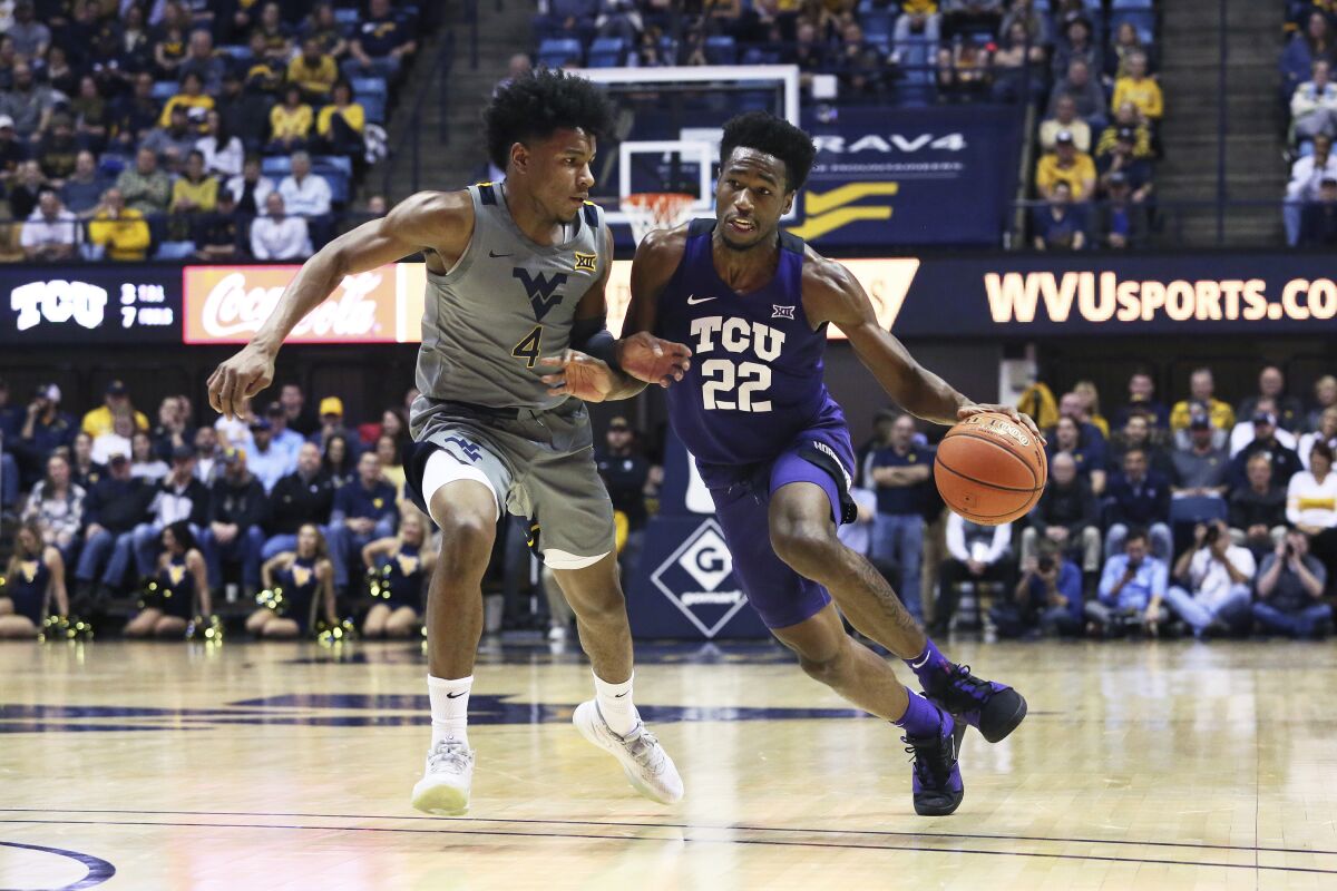FILE - TCU guard RJ Nembhard (22) is defended by West Virginia guard Miles McBride during the first half of an NCAA college basketball game in Morgantown, W.Va., in this Tuesday, Jan. 14, 2020 file photo. TCU coach Jamie Dixon isn't expecting center Kevin Samuel and guard RJ Nembhard to play more minutes this season. The team's only returning starters just need to be more efficient when on the court. (AP Photo/Kathleen Batten, File)