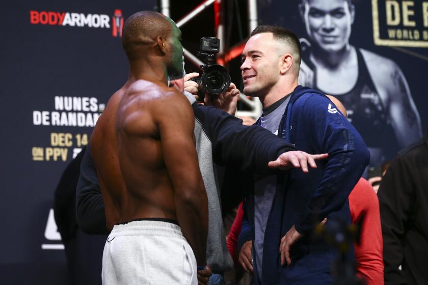 Kamaru Usman, left, and Colby Covington face off during the ceremonial weigh-in event ahead of their fight in UFC 245 at T-Mobile Arena in Las Vegas, Friday, Dec. 13, 2019. (Chase Stevens/Las Vegas Review-Journal via AP)