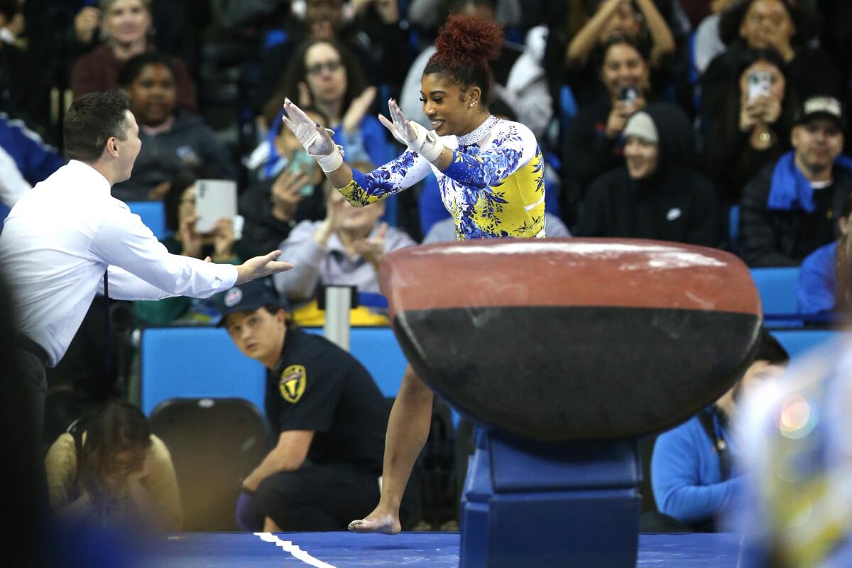 UCLA's Nya Reed is congratulated after scoring a 9.85 on the vault during a dual meet with Utah on Monday.