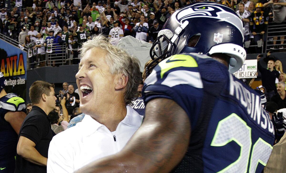 Seattle Seahawks Coach Pete Carroll celebrates with Michael Robinson after the team's 14-12 win in the infamous "fail mary" game against the Green Bay Packers in 2012.