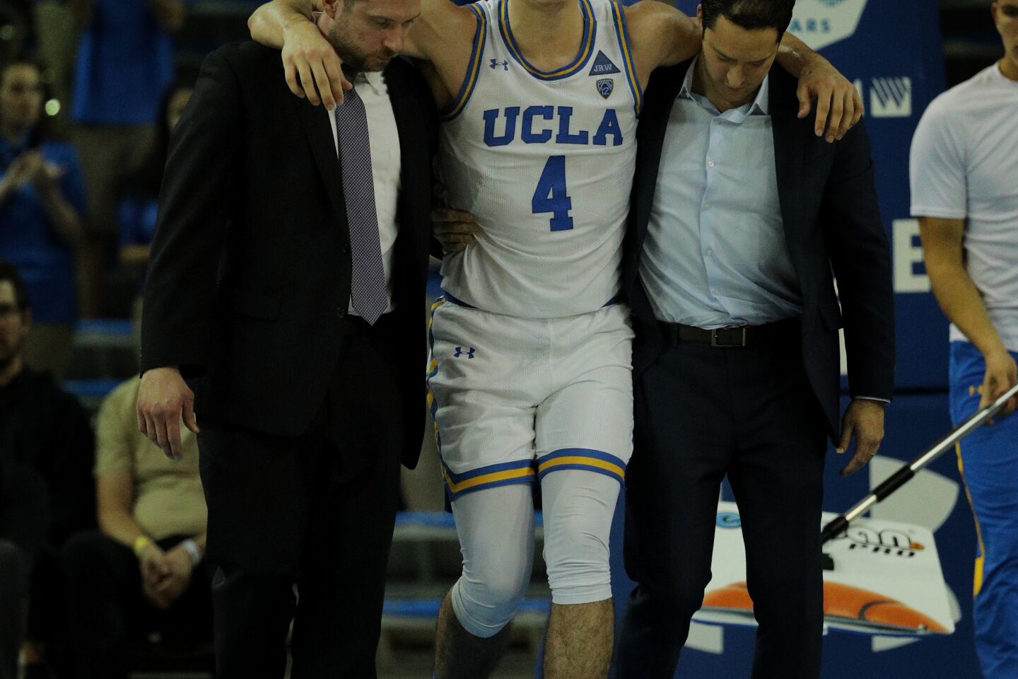 Bruins guard Jaime Jaquez Jr. is helped off the court after injuring a leg during the second half.