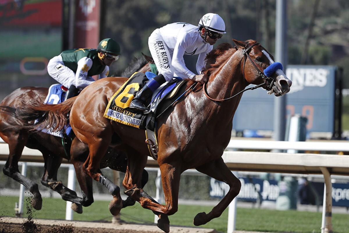 Jockey Mike Smith lurges Justify past Bolt d'Oro and jockey Javier Castellano during the Santa Anita Derby in 2018.