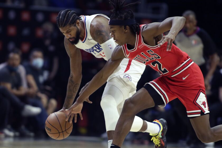 Chicago Bulls guard Ayo Dosunmu, right, reaches in but Los Angeles Clippers guard Paul George.