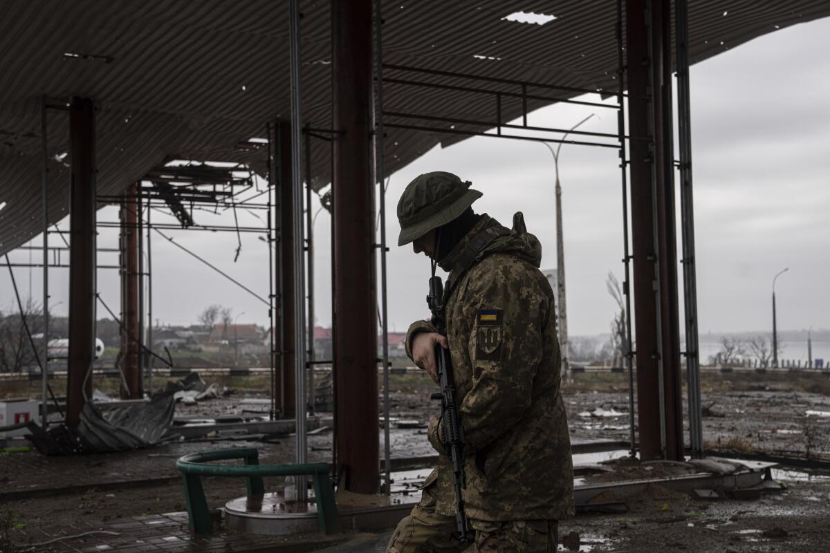 A Ukrainian serviceman patrols near a bridge.