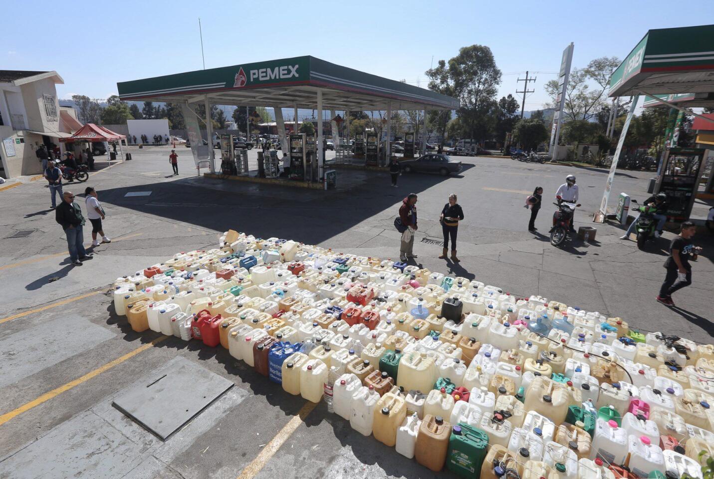 People wait for a gasoline delivery at a gas station Jan. 9 in Morelia.