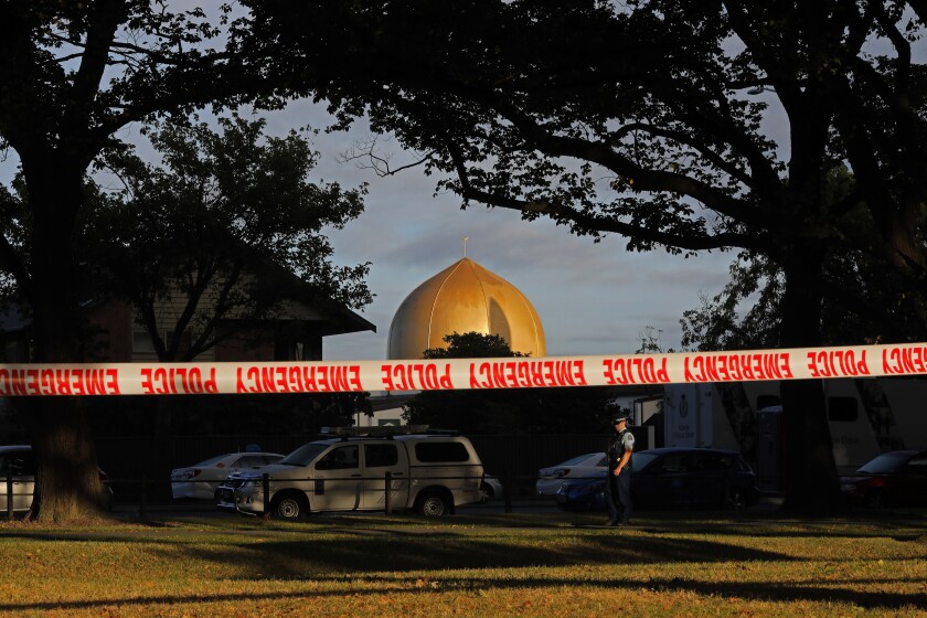 FILE - In this March 17, 2019, file photo, police officer stands guard in front of the Masjid Al Noor mosque in Christchurch, New Zealand, where one of two mass shootings occurred. A New Zealand man is facing criminal charges after allegedly posting online threats against two Christchurch mosques that were the sites of a terrorist attack that left 51 people dead. Police on Thursday, March 4, 2021, arrested the 27-year-old man and charged him with threatening to kill. If found guilty, he faces a maximum prison sentence of seven years. (AP Photo/Vincent Yu, File)