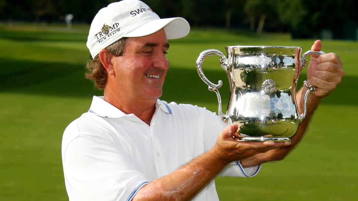 Gene Sauers checks out the trophy after winning the U.S. Senior Open on Monday.