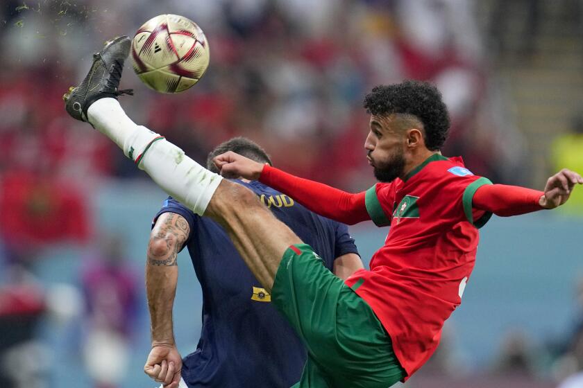 Morocco's Noussair Mazraoui connects a shot during the World Cup semifinal soccer match.