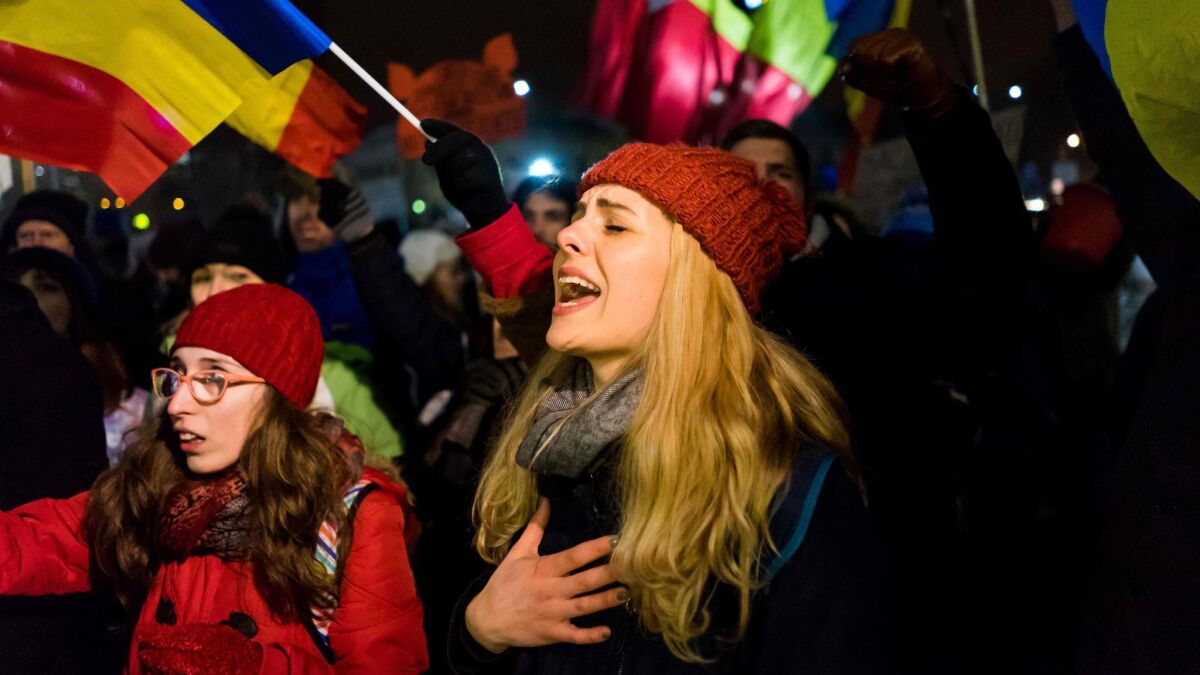 A young woman sings during a protest against the government in Bucharest, Romania, on Sunday.