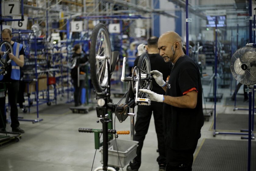 Brompton folding bicycles are assembled by hand at the Brompton factory in west London, Tuesday, Nov. 24, 2020. The team at Brompton Bicycles company thought they were prepared for Britain's Brexit split with Europe, but they face uncertainty about supplies and unexpected new competition from China, all amid a global COVID pandemic.(AP Photo/Matt Dunham)