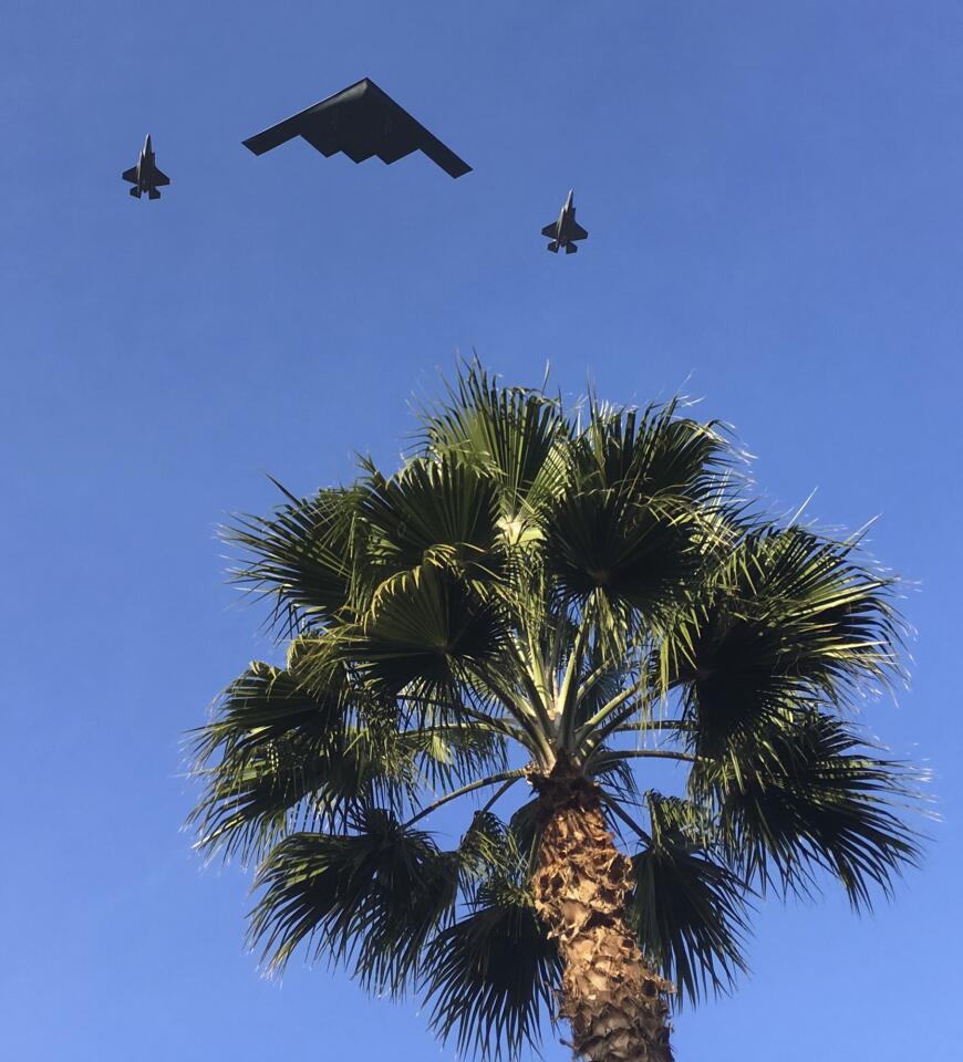 A B-2 Spirit, also known as the Stealth Bomber, and two fighters jets fly over the 2018 Rose Parade route in Pasadena.