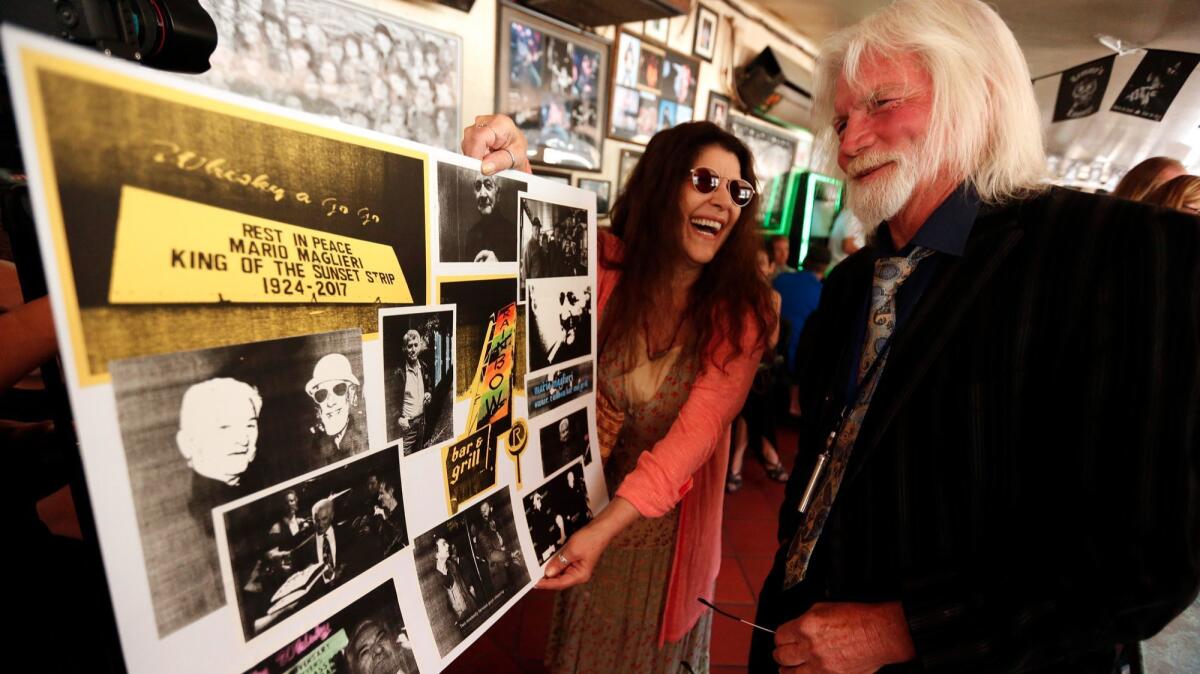 Sheila Lightfoot shows Jim Maley images she put together in memory of Mario Maglieri during a memorial for the late-night club owner.