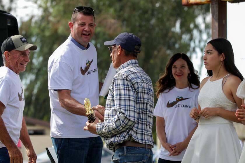 Buttonwillow, CA - October 22: Rep. David Valadao, 45, is campaigning to keep his seat in congress in the race for the newly drawn congressional district 22. The republican incumbent is a dairy farmer from Hanford who has focused his campaign on water issues plaguing the central valley's agriculture community. Valadao, second from left, campaigns at Buttonwillow Fall Farm Festival on Saturday, Oct. 22, 2022 in Buttonwillow, CA. (Irfan Khan / Los Angeles Times)