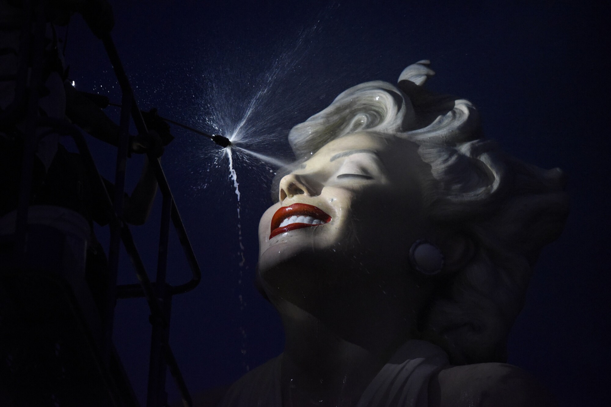 The sculpture "Forever Marilyn" is sprayed at night during the sculpture's installation.