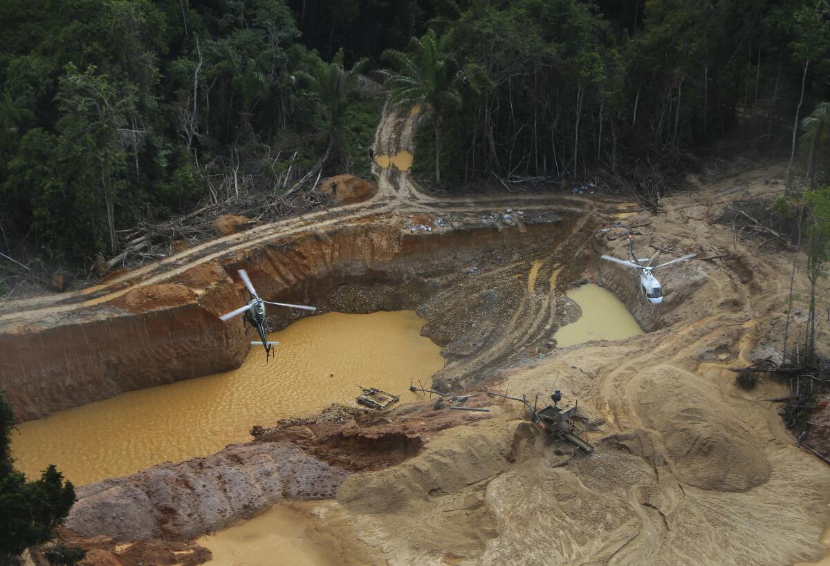 A Brazil Environmental Agency helicopter flies over an illegal mining camp in Yanomami Indigenous territory.
