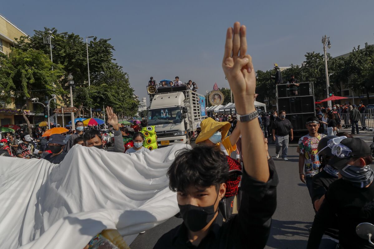 Students led pro-democracy protesters flash three-finger salute as they march to the Democracy Monument in Bangkok, Thailand, Saturday, Nov. 14, 2020. (AP Photo/Sakchai Lalit)