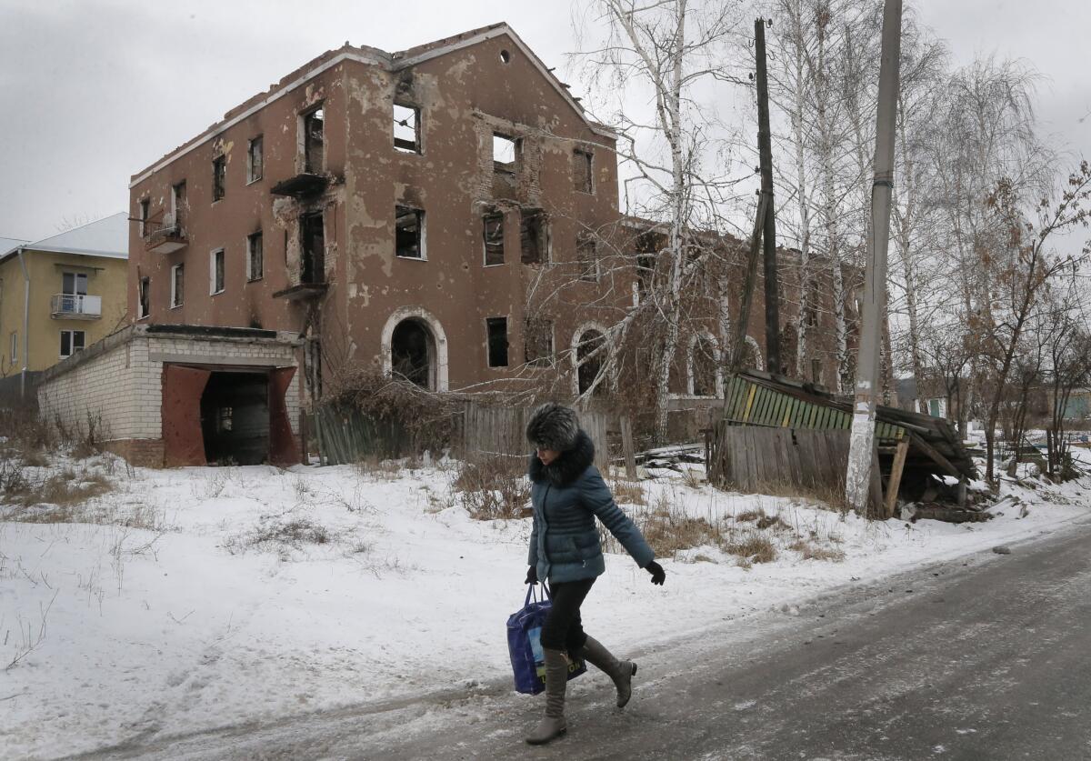 A woman passes by a house destroyed in recent battles between the Ukrainian army and pro-Russian separatists in the Donetsk region of eastern Ukraine.