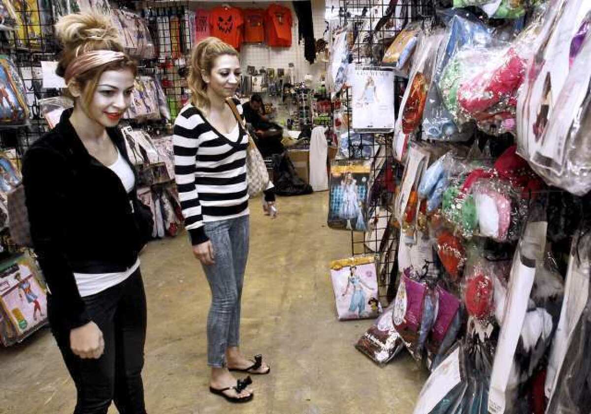 Lara Kay, left, and Gina Dermamjian, right, both 23 and from Burbank, look for Halloween costumes at Halloween Superstore on Brand Boulevard in Glendale on Tuesday.