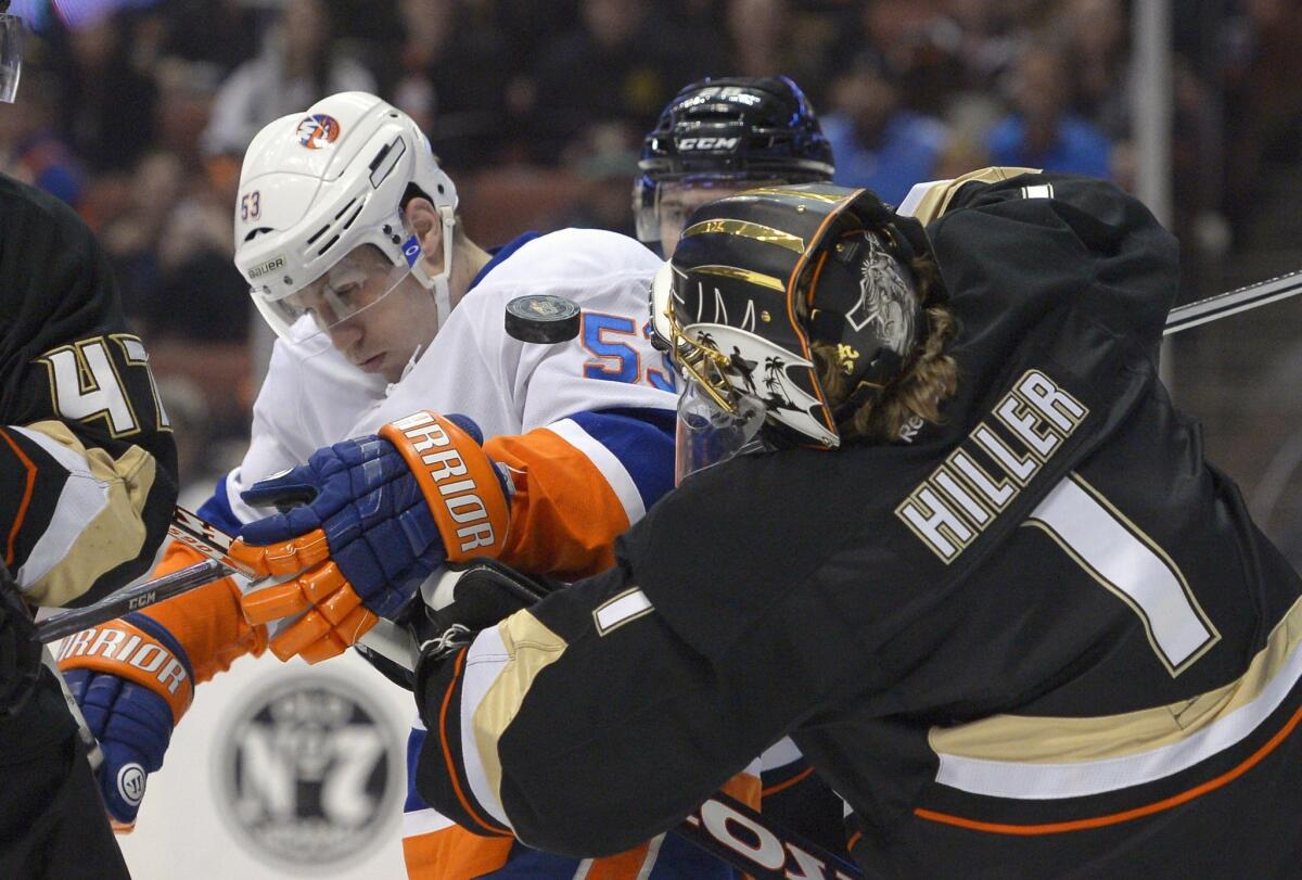 Ducks goalie Jonas Hiller battles New York Islanders center Casey Cizikas for a loose puck during the Ducks' 5-2 win Monday.