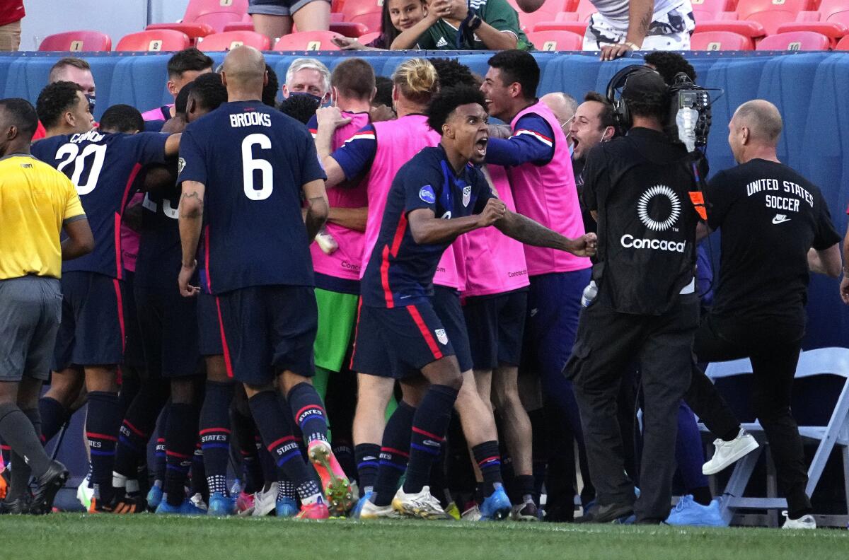 United States' Weston McKennie, front, celebrates a goal by Jordan Siebatcheu (16) against Honduras.