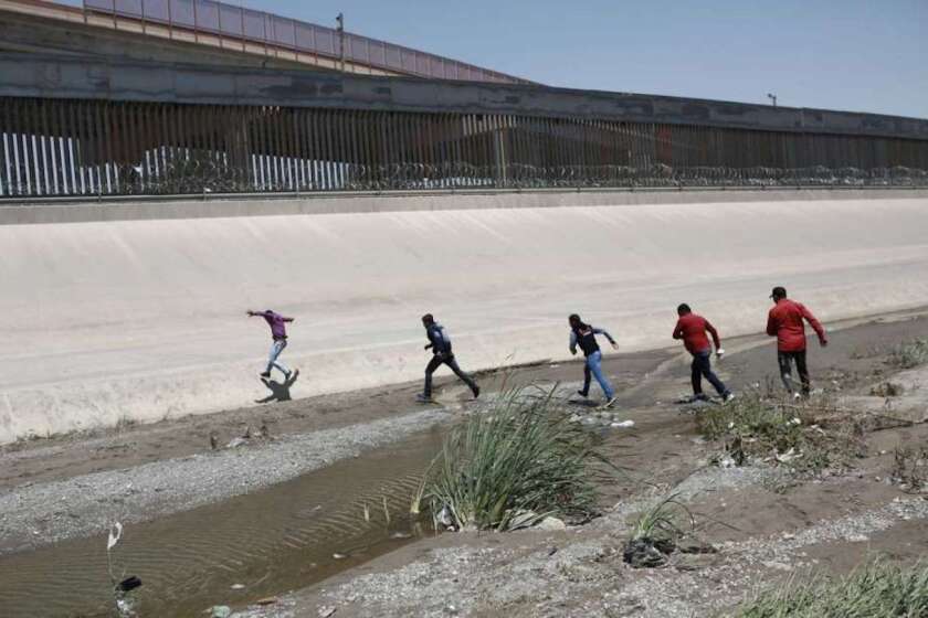 Migrantes cruzando el Río Bravo sin autorización para entregarse a las autoridades estadounidenses en la frontera entre México y Estados Unidos entre Ciudad Juárez y El Paso.