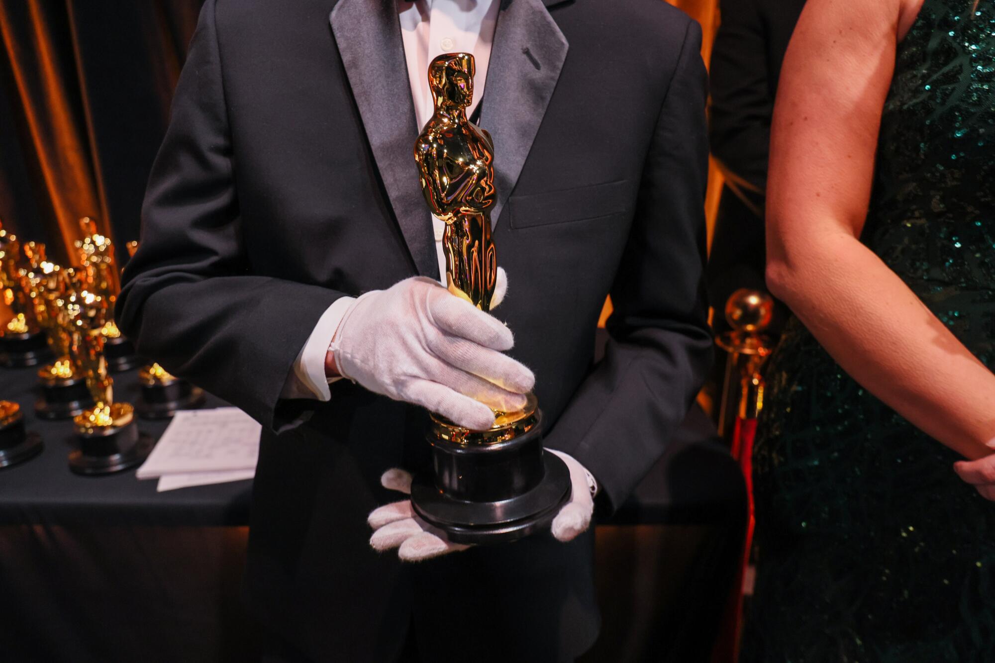 A man holds an Academy Awards trophy.
