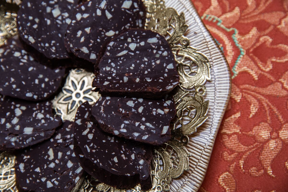 A dessert called Chocolate Sausage is sliced and ready to serve.