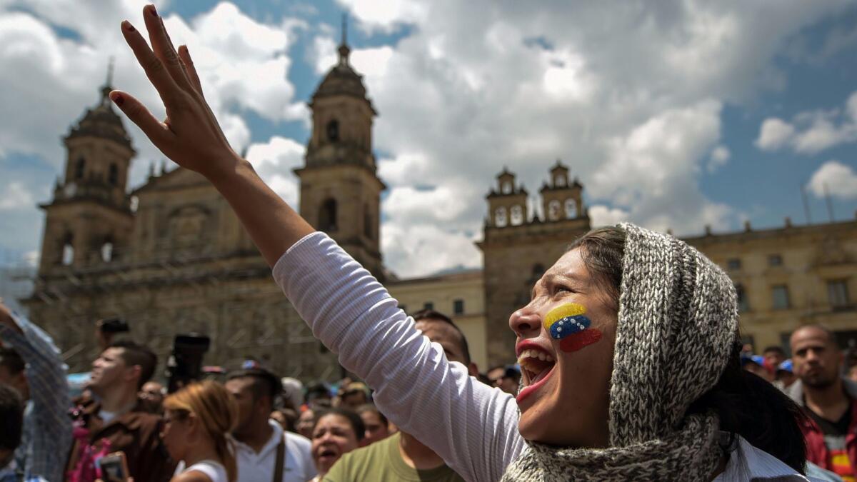 Venezuelans residing in Colombia gather at Bolivar Square in Bogota to take part in a symbolic plebiscite on plans for a constitutional overhaul in their home country.