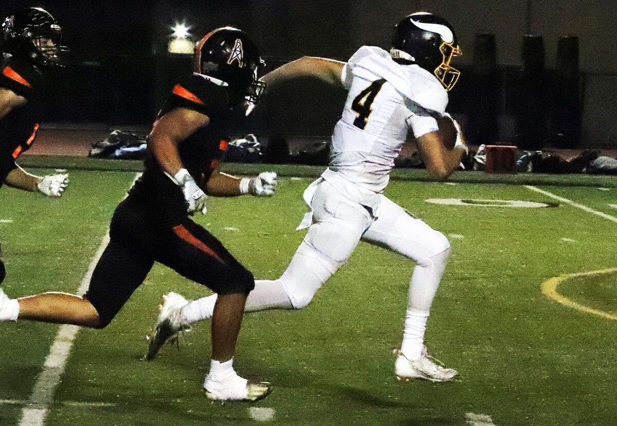 Marina's Payton Ekstedt (4) runs for considerable yardage after catching a pass against Huntington Beach on Thursday.