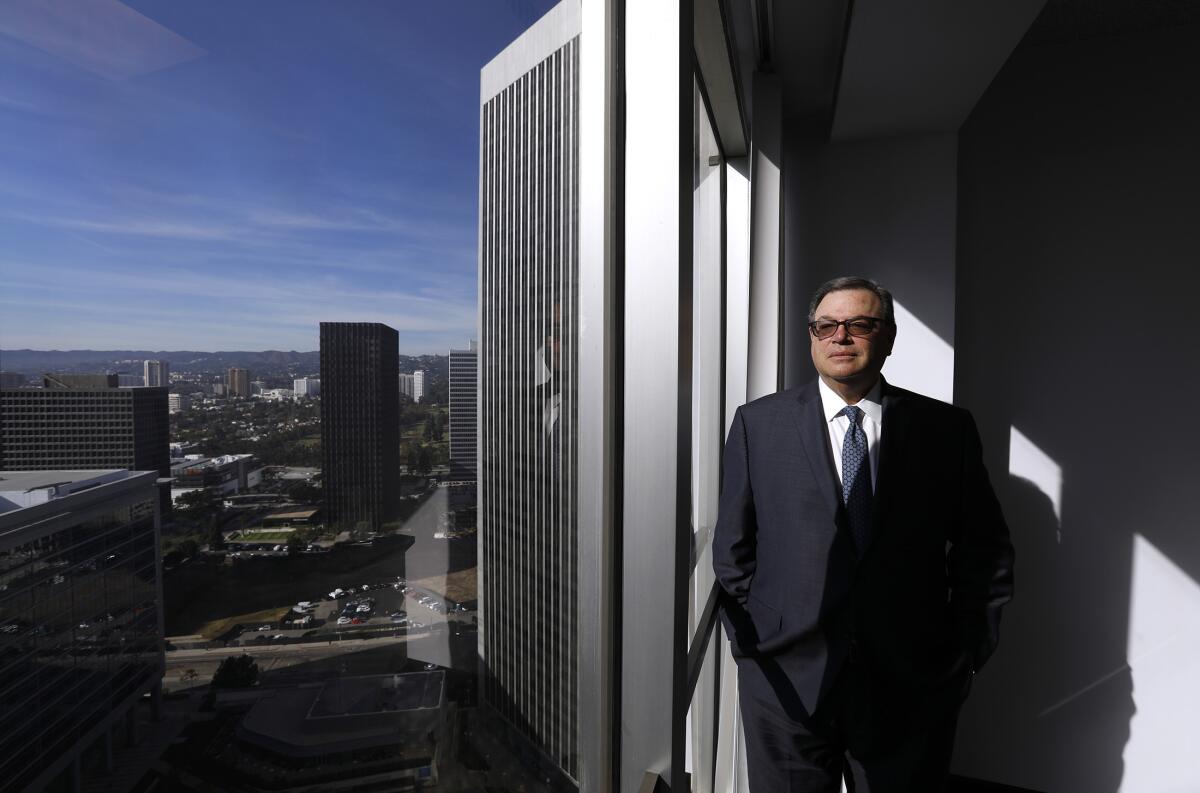 Hollywood attorney Martin D. Singer leans against his high-rise office window in a suit and sunglasses