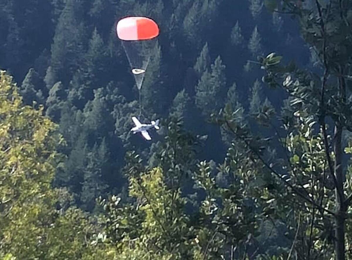 An image provided by the Shelter Cove Fire Dept. shows a plane deploying a parachute system that eased the plane’s landing.