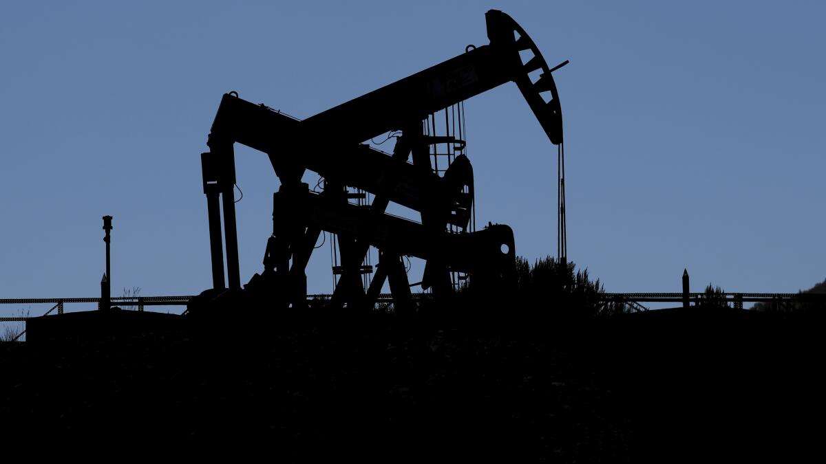 Pumpjacks are shown in silhouette.