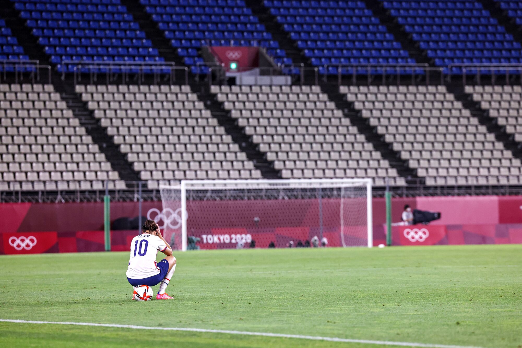 USA's Carli Lloyd sits alone on the field.