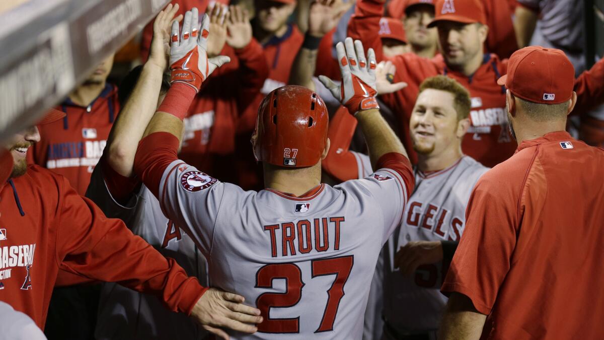 Angels center fielder Mike Trout is congratulated by his teammates during Friday's game against the Seattle Mariners.