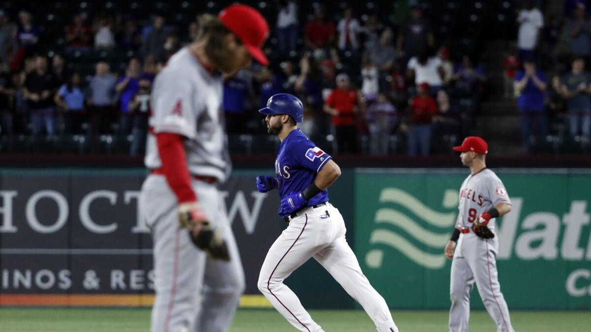 Angels pitcher Dillon Peters, left, stands on the mound and second baseman Tommy La Stella looks to the outfield as Texas Rangers' Joey Gallo rounds the bases on his two-run home run during the sixth inning in Arlington, Texas on April 16, 2019.