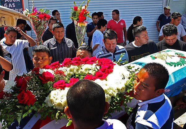 Family members and friends carry the casket of Manuel Jaminez Xum out of the church and into the hearse, following his wake in Los Angeles.