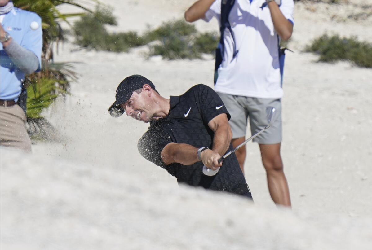 Rory McIlroy, of Northern Ireland, hits out of a bunker on the 5th hole during the first round of the Hero World Challenge PGA Tour at the Albany Golf Club, in New Providence, Bahamas, Thursday, Dec. 2, 2021.(AP Photo/Fernando Llano)