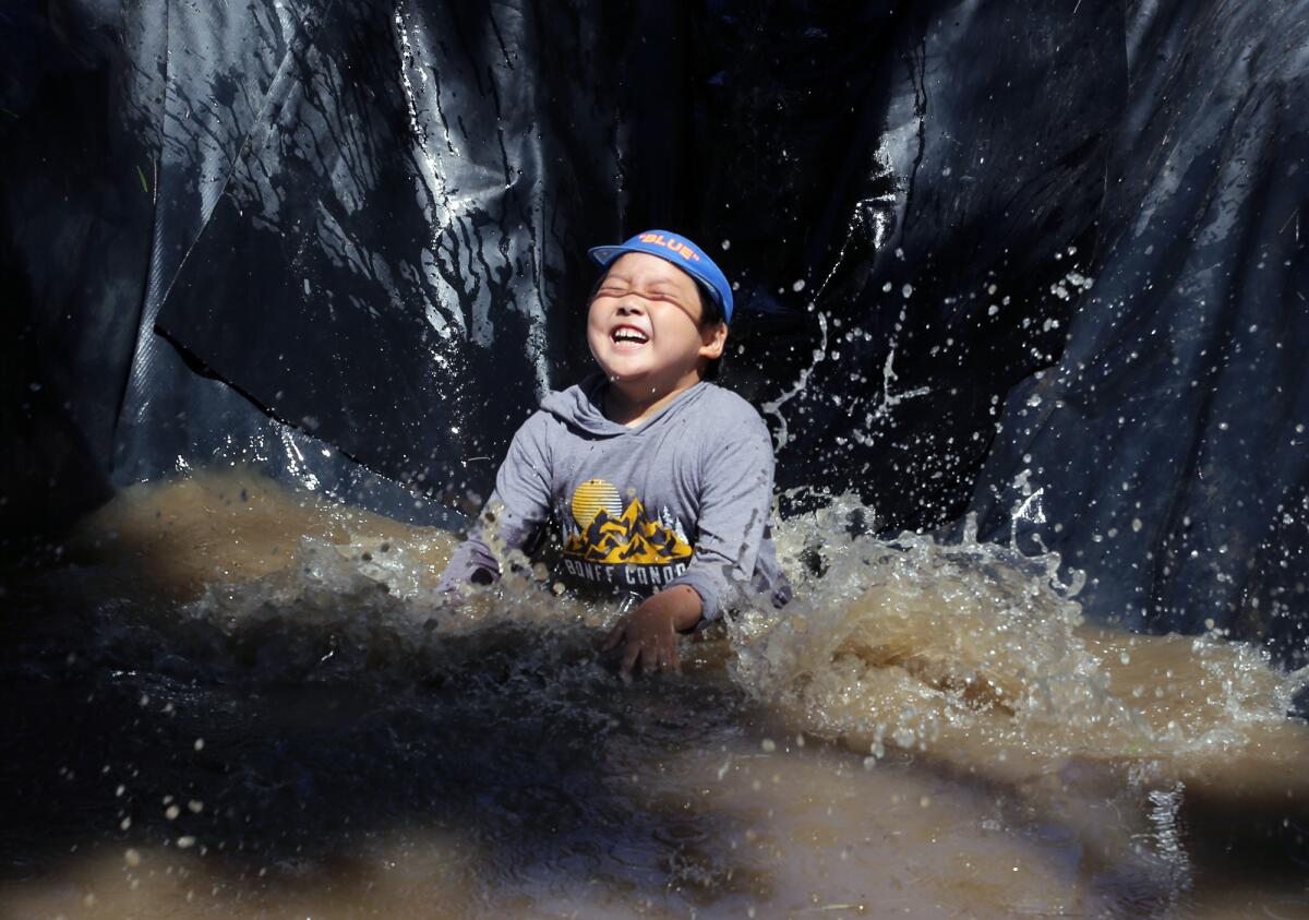 Minjun Chang splashes into muddy water during the opening day of Adventure Playground in 2023.