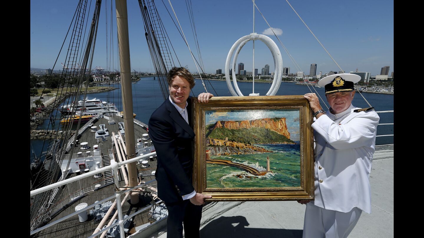 Duncan Sandys, left, great-grandson of Sir Winston Churchill, and Commodore Everett Hoard hold up a painting done by Churchill titled "Coast Scene Near Marseilles," a 1930s oil on canvas. This and other paintings will be on exhibit at an art gallery aboard the Queen Mary in Long Beach. A total of 10 paintings done by Churchill will be included in the exhibit running from May 27 to Dec. 31, 2016.