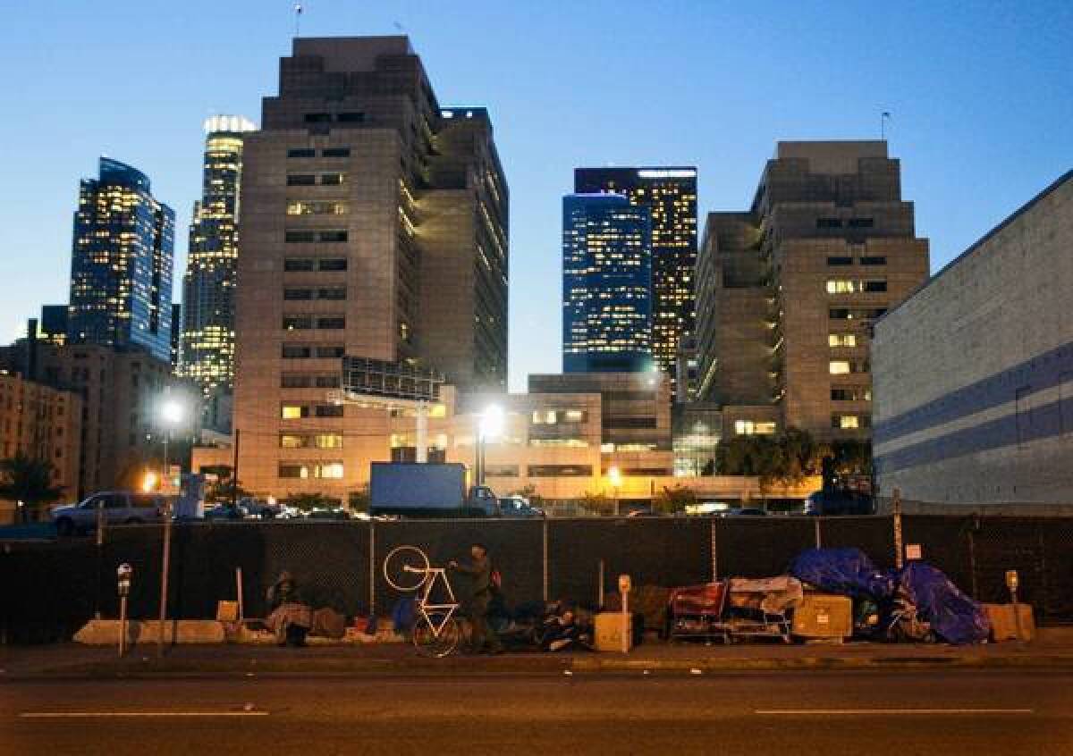 Homeless people gather along Los Angeles Street on skid row. City officials are seeking to overturn a court ruling preventing the removal of homeless people's unattended belongings from sidewalks. The case could have broad implications for other cities.