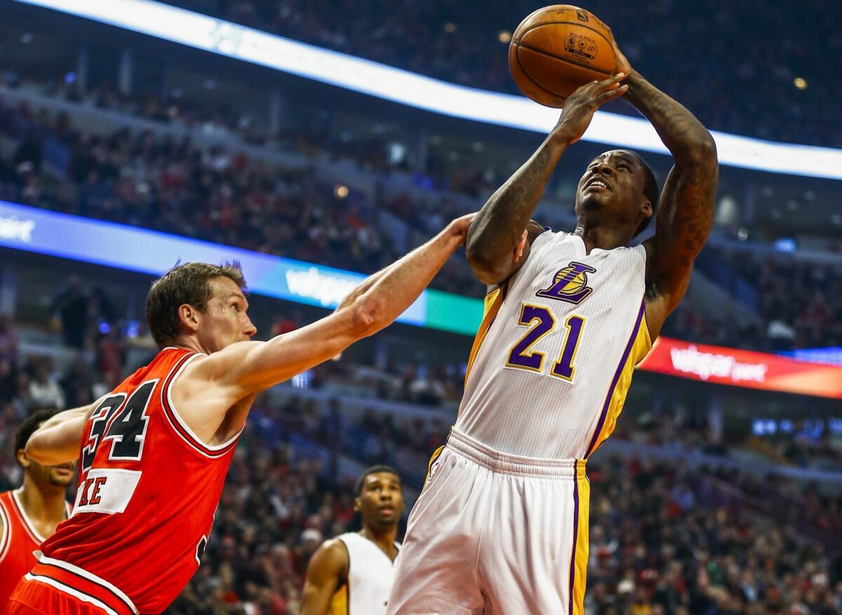 Lakers forward Ed Davis (21) is fouled by Bulls forward Mike Dunleavy while attempting a shot in the first half Thursday in Chicago.