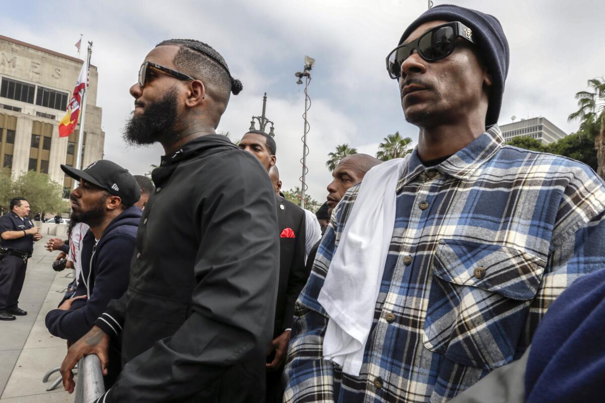 Rappers the Game, left, and Snoop Dogg stand outside LAPD headquarters during a peaceful march earlier this month.