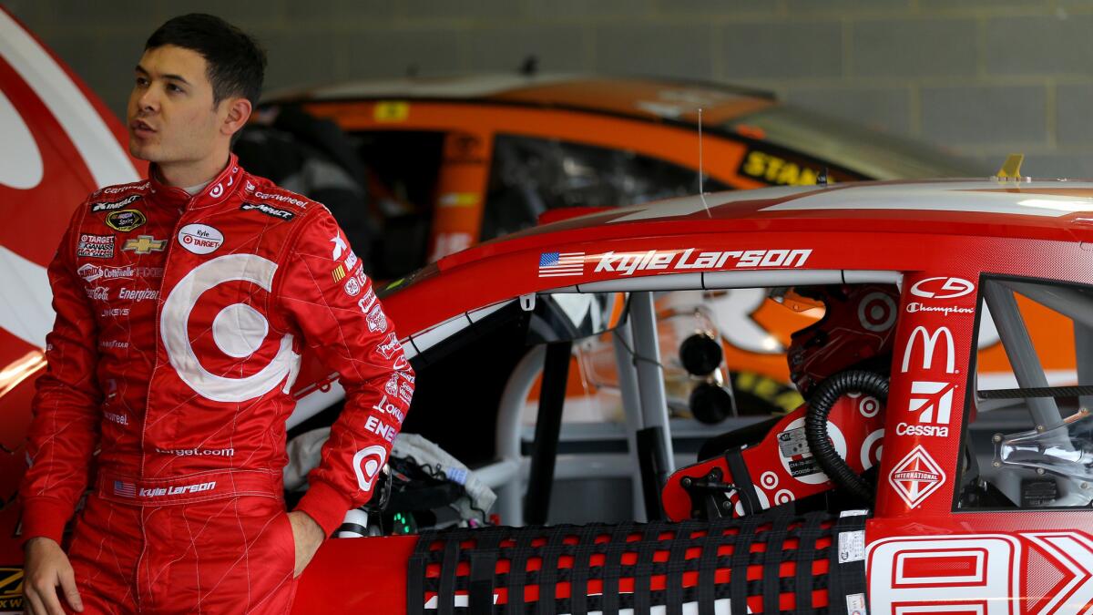 Kyle Larson stands next to his car during NASCAR Sprint Cup practice at Martinsville Speedway on Friday, the day before he fainted at an autograph session.